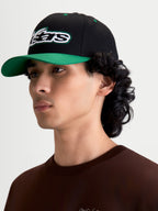 Alpinestars Retro Snapback Hat, Sportswear Casual Cap worn by male model, Black and Green, featuring a curved bill, structured crown, and bold embroidered Astars logo with green running stitch, premium cotton twill construction.