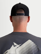 Alpinestars Combo Logo Snapback Hat, Sportswear Cap for Men and Women, Black, Durable Cotton Twill, Rear View on Model showing the Adjustable Snapback Closure and Small White Logo Detail.