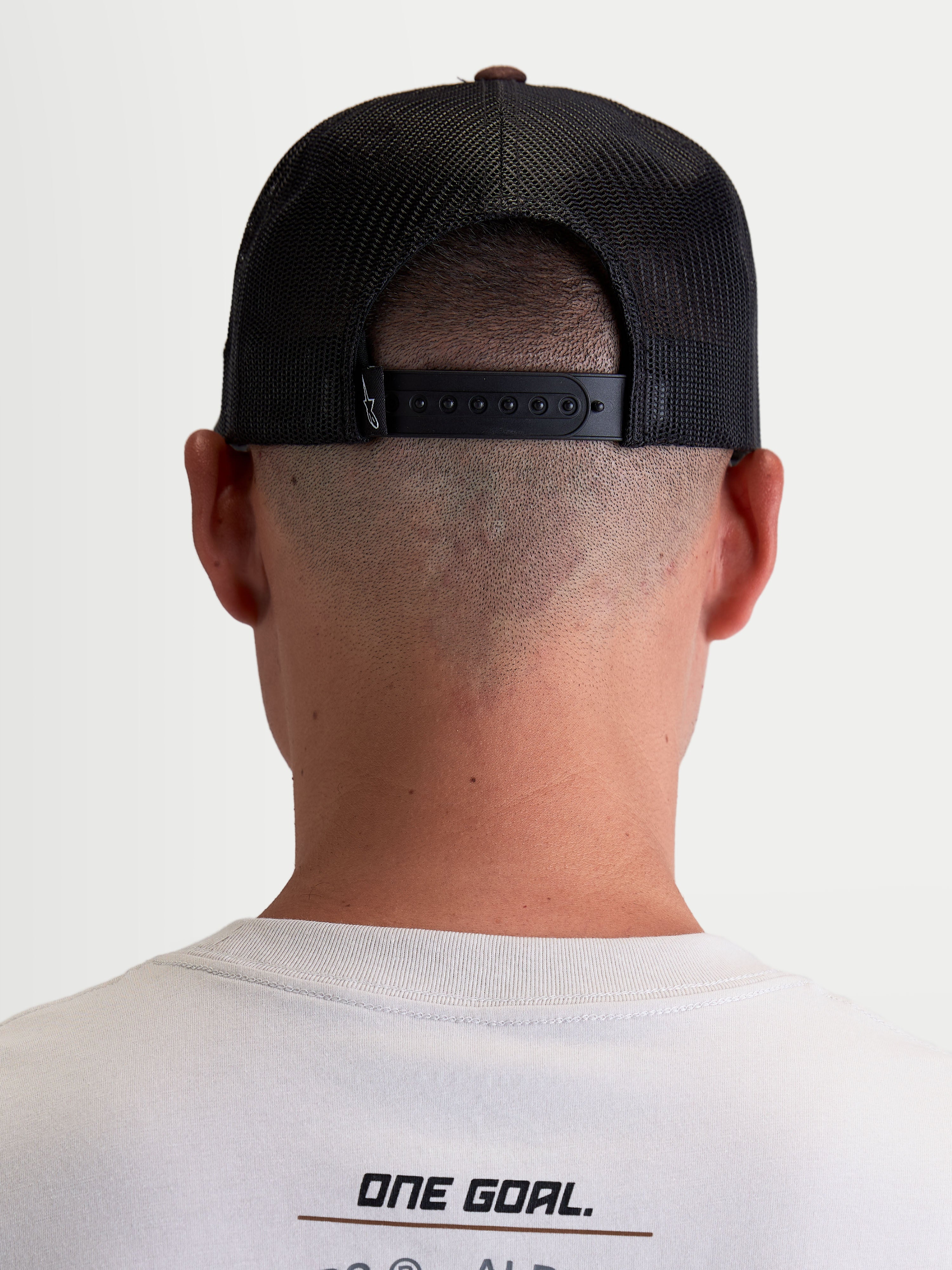 Alpinestars Hotlink Trucker Hat, Sportswear Lifestyle Cap, Unisex, Brown and Black, Rear view on-model showing adjustable snapback closure, mesh back panels for breathability, and premium branding detail.