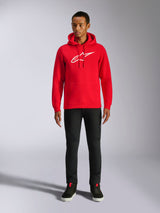 Alpinestars Ageless V3 Hoodie, casual streetwear, Red with white embroidered Alpinestars logo, worn by a male model with black pants, drawstring hood, front kangaroo pocket, modern motorsport-inspired design