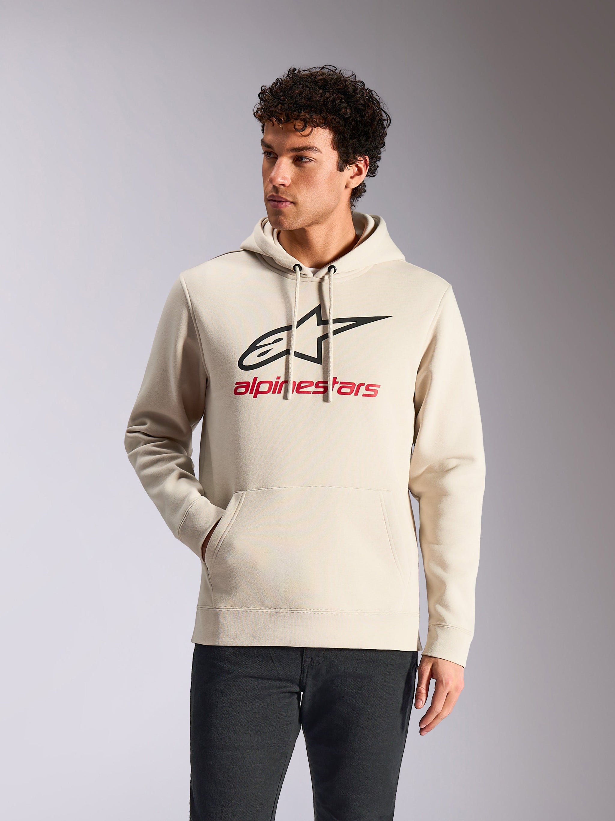 Alpinestars Always V3 Hoodie, casual sportswear, off-white with black star logo and red branding, drawstring hood, front kangaroo pocket, worn by model with dark pants, modern motorsport-inspired design