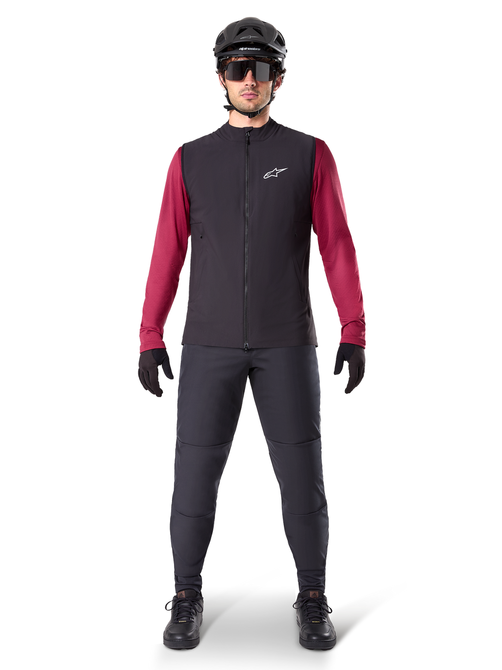 Alpinestars A-Dura Thermal Vest, Black cycling gilet worn over a maroon long-sleeve jersey, paired with dark grey MTB pants, black helmet and sunglasses, technical mountain bike apparel for cold-weather riding