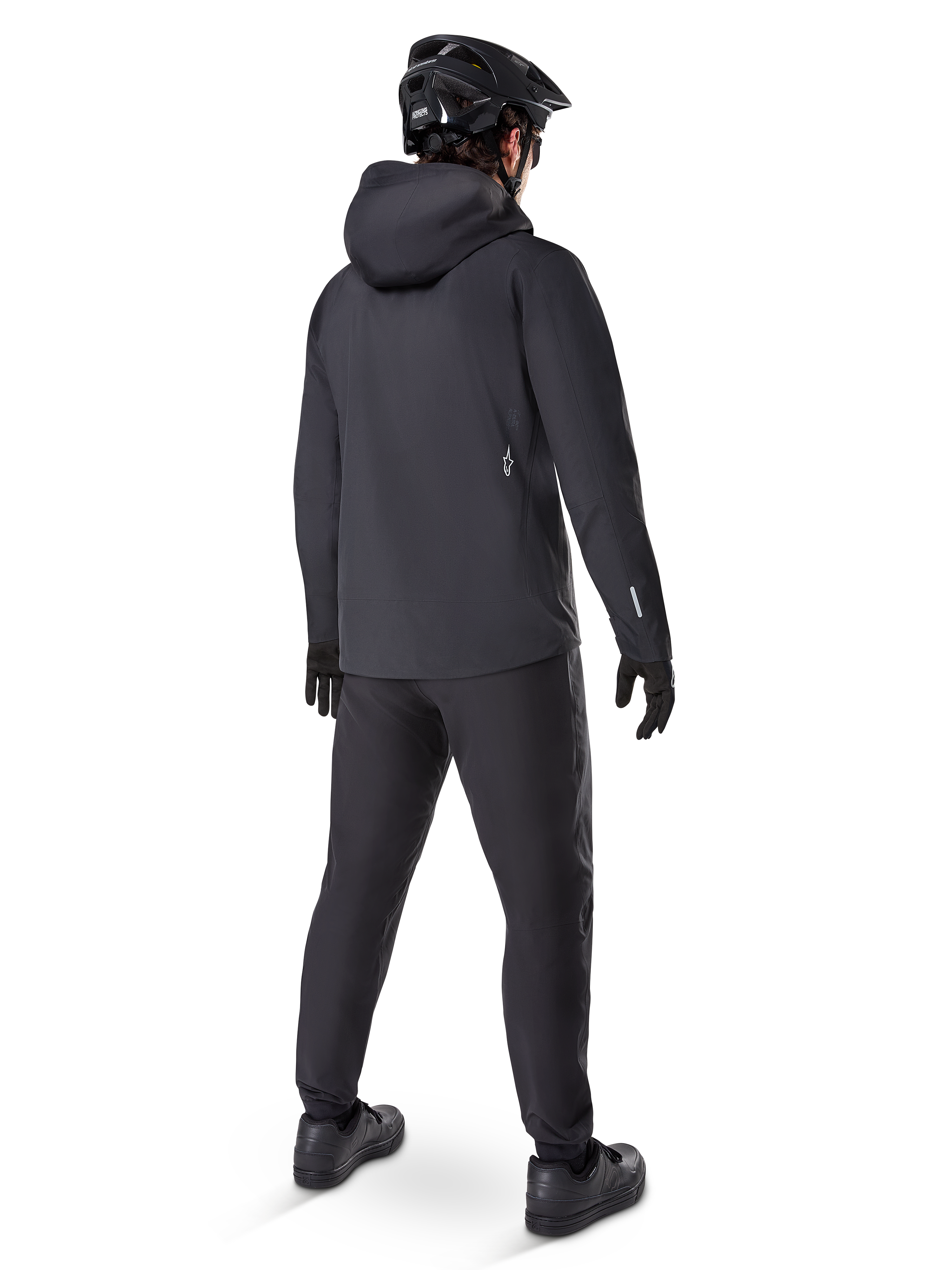 Alpinestars A-Dura Waterproof Pants, MTB pants, Black, shown from the rear on a rider wearing a full black mountain biking outfit including a hooded jacket and helmet, durable waterproof gear for muddy trails