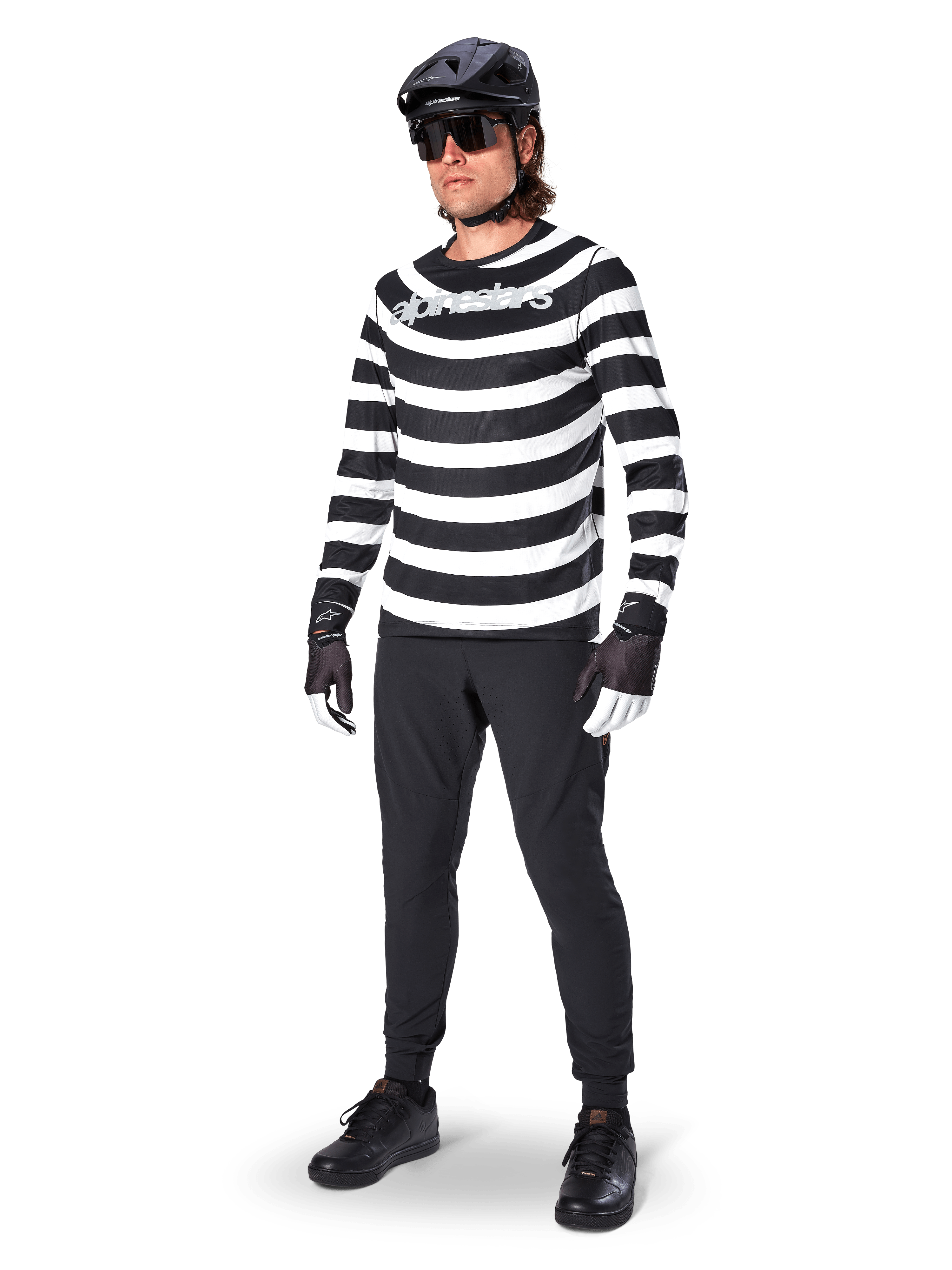 Alpinestars A-Aria Elite Pants, Black MTB Pants, worn by a rider with a black and white striped long-sleeve jersey, black helmet, sunglasses, and black and white gloves, performance gear for off-road cycling