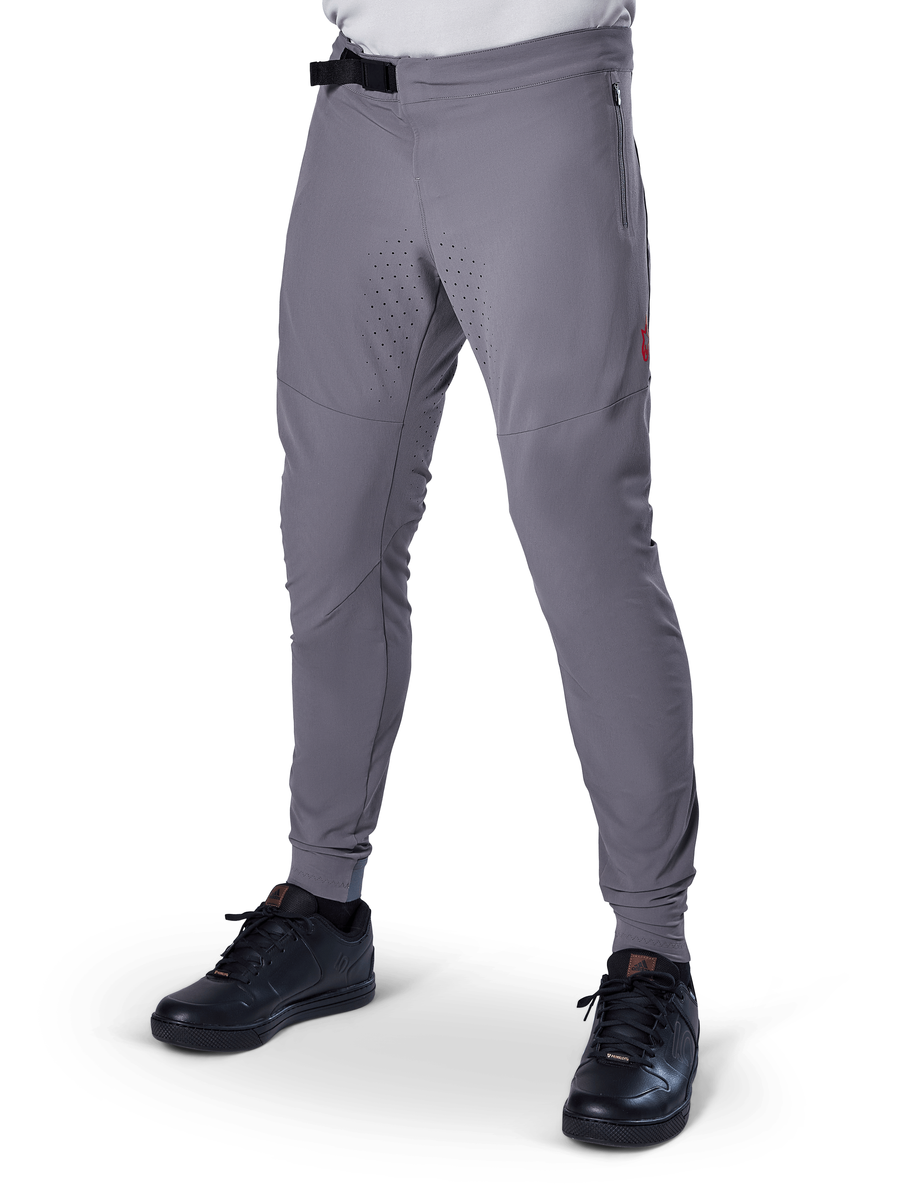 Alpinestars A-Aria Elite Pants, Dark Gray MTB Pants, laser perforated panels on thighs, black magnetic buckle closure, zippered pocket, red logo detail, slim performance fit, worn with black shoes