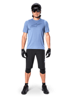 Alpinestars A-Dura Elite Shorts, Black Mountain Bike Shorts, worn with a light blue t-shirt, black helmet, sunglasses, and knee pads, professional off-road cycling apparel