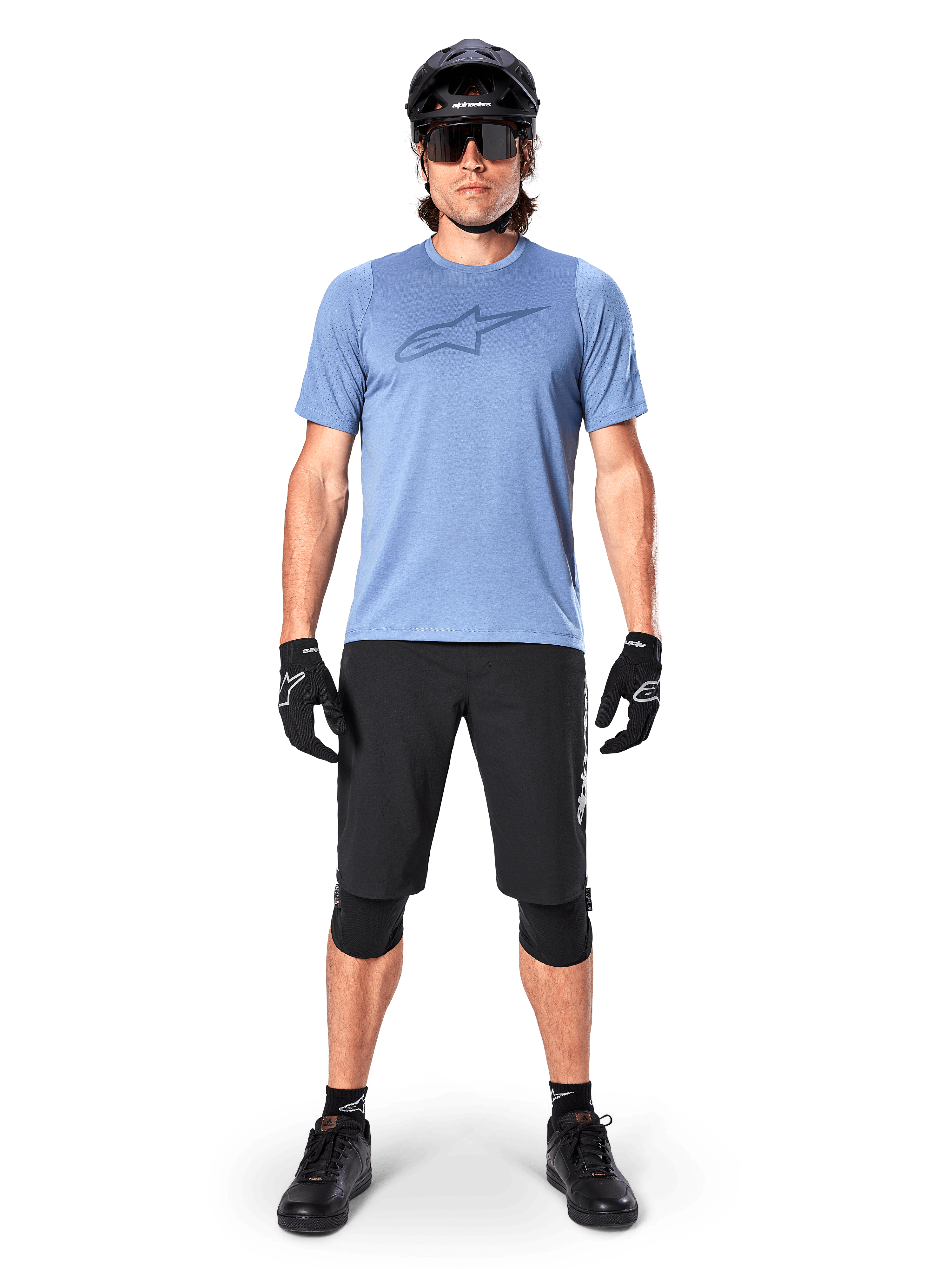 Alpinestars A-Dura Elite Shorts, Black Mountain Bike Shorts, worn with a light blue t-shirt, black helmet, sunglasses, and knee pads, professional off-road cycling apparel