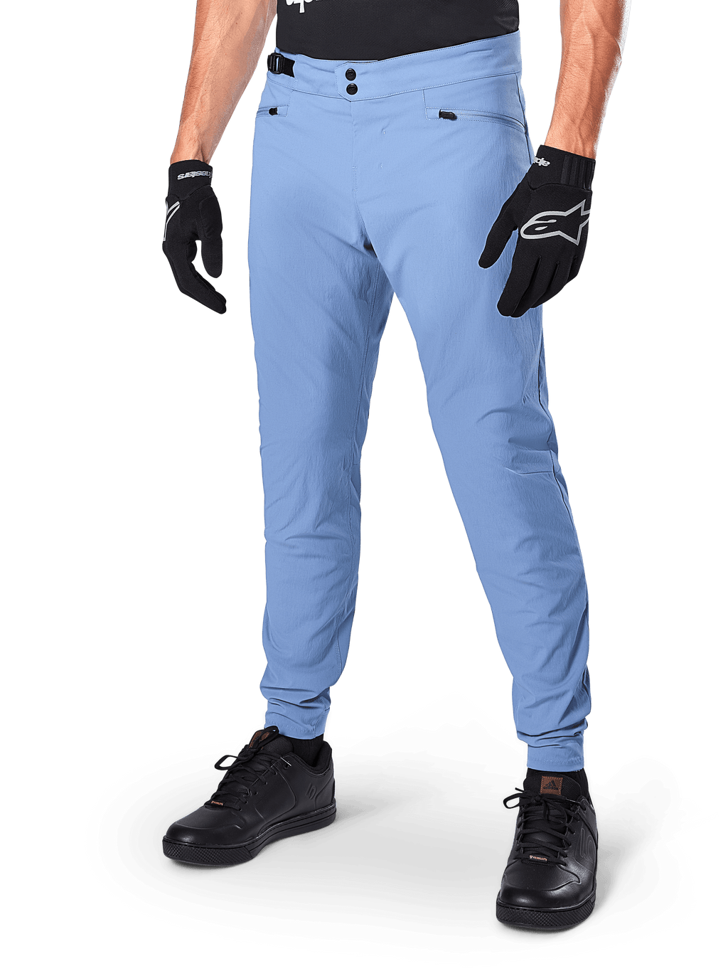 Alpinestars A-Dura Pants, Infinity Blue MTB Cycling Pants, featuring double snap front closure and zippered pockets, worn with black gloves and black shoes, durable 2-way stretch textile for off-road riding