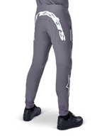 Alpinestars A-Supra Race Pants, Mountain Bike Pants, Dark Gray, rear view worn with black shoes, featuring a large white Alpinestars wordmark on the back yoke and star logo on the leg, zippered pocket, performance stretch fabric for MTB racing