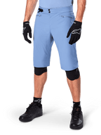 Alpinestars A-Dura Shorts, Infinity Blue, Mountain Bike Shorts, featuring zippered pockets and double snap closure, worn with black gloves and knee pads, durable 2-way stretch fabric for MTB