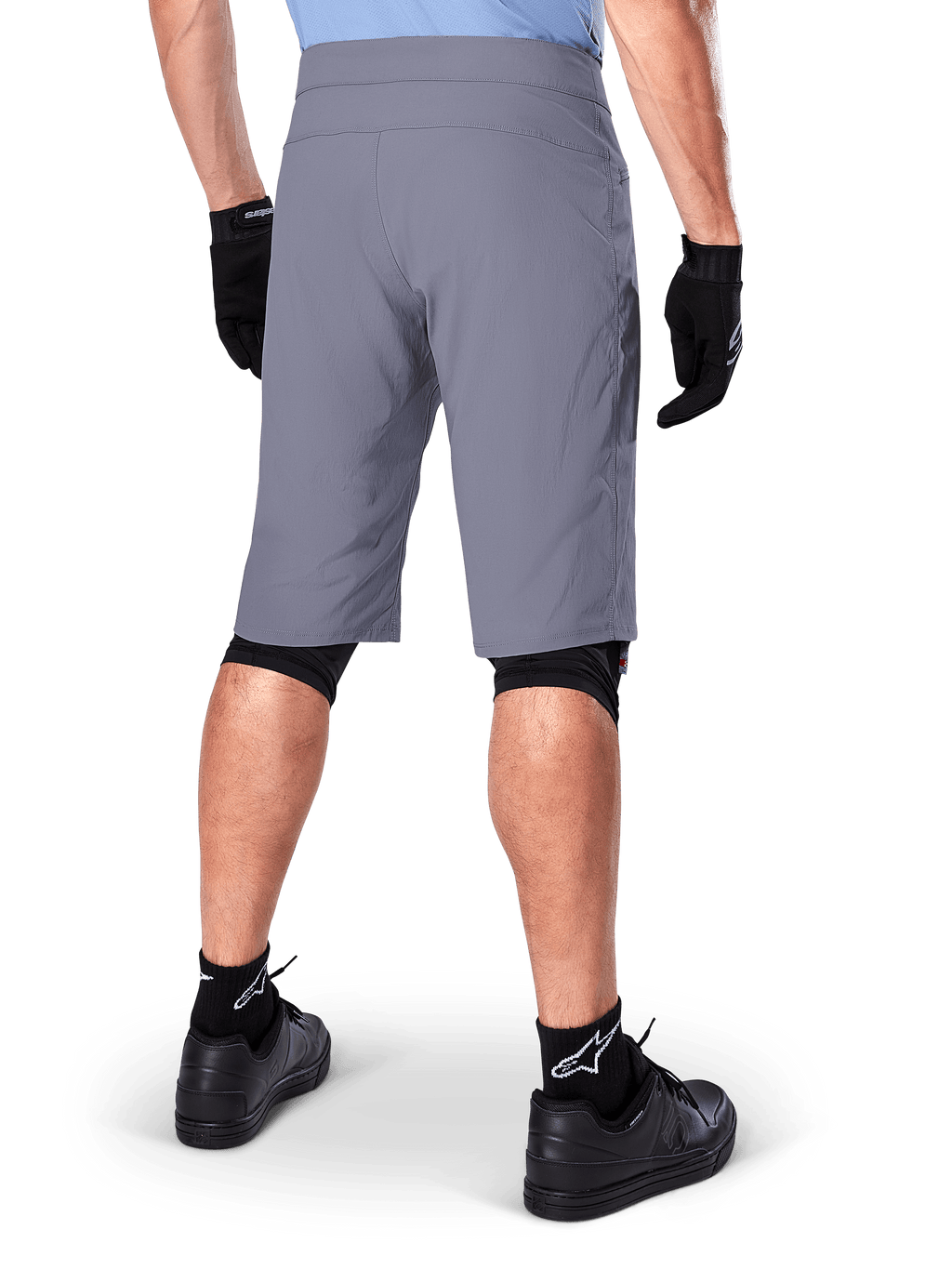 Alpinestars A-Dura Shorts, Dark Gray Mountain Bike Shorts, rear view shown on a rider, worn with black gloves, black knee liners, and black Alpinestars logo socks, durable construction for off-road cycling
