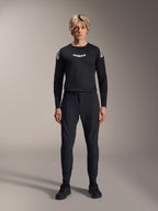 Alpinestars A-Aria Elite Pants, Black Titanium MTB Pants, worn by a male model with a matching black long-sleeve jersey and sneakers, slim-fit performance design with magnetic buckle closure, technical mountain bike apparel