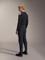 Alpinestars A-Aria Elite Pants, Mountain Bike Pants, Black Titanium, rear three-quarter view on model, featuring white Alpinestars branding on the lower legs, performance fit with elastic cuffs, paired with a matching black long-sleeve jersey.