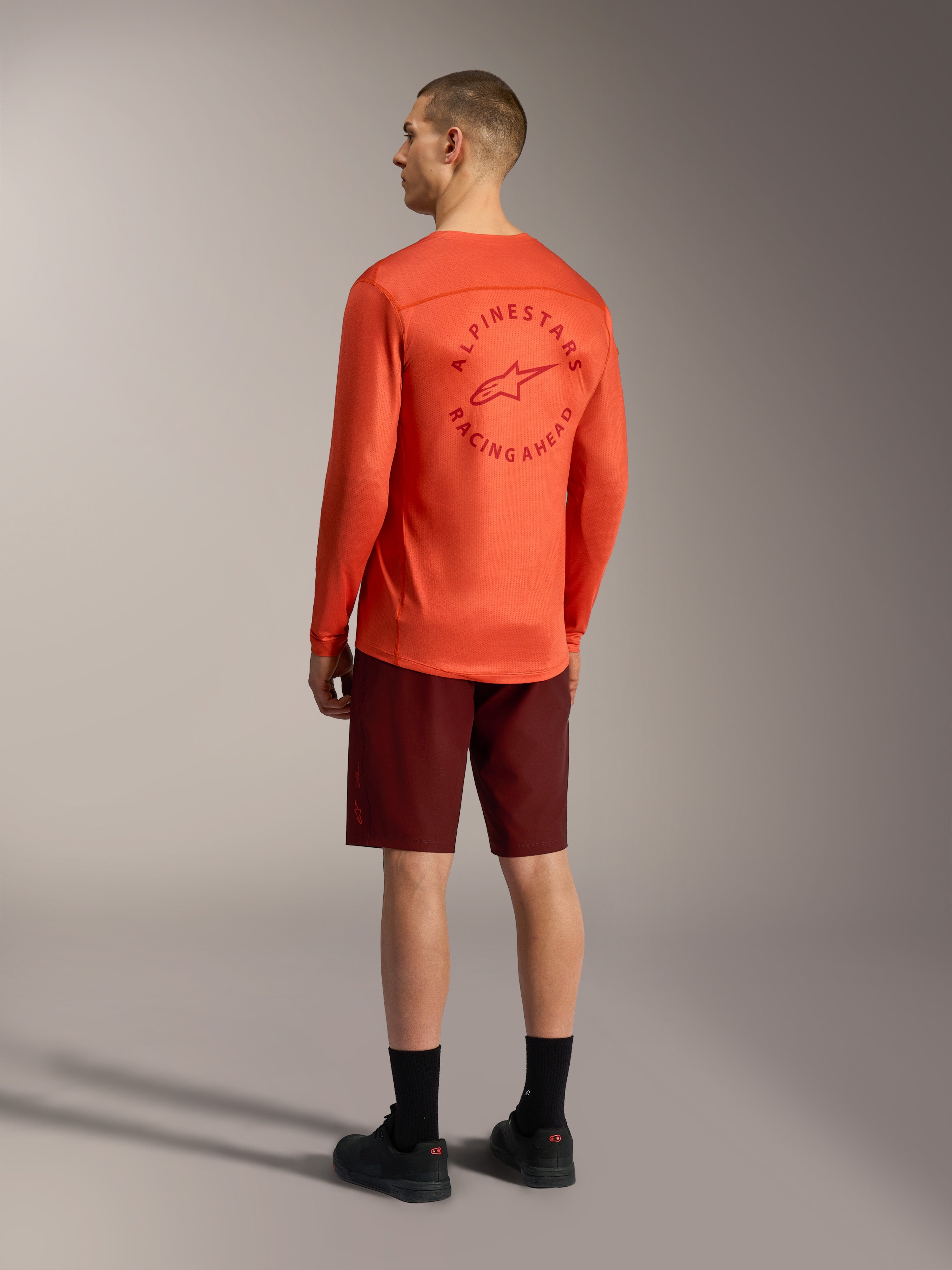 Orange A-Dura Air long-sleeve jersey with back graphic and bordeaux A-Dura Ride Shorts, performance MTB gear.