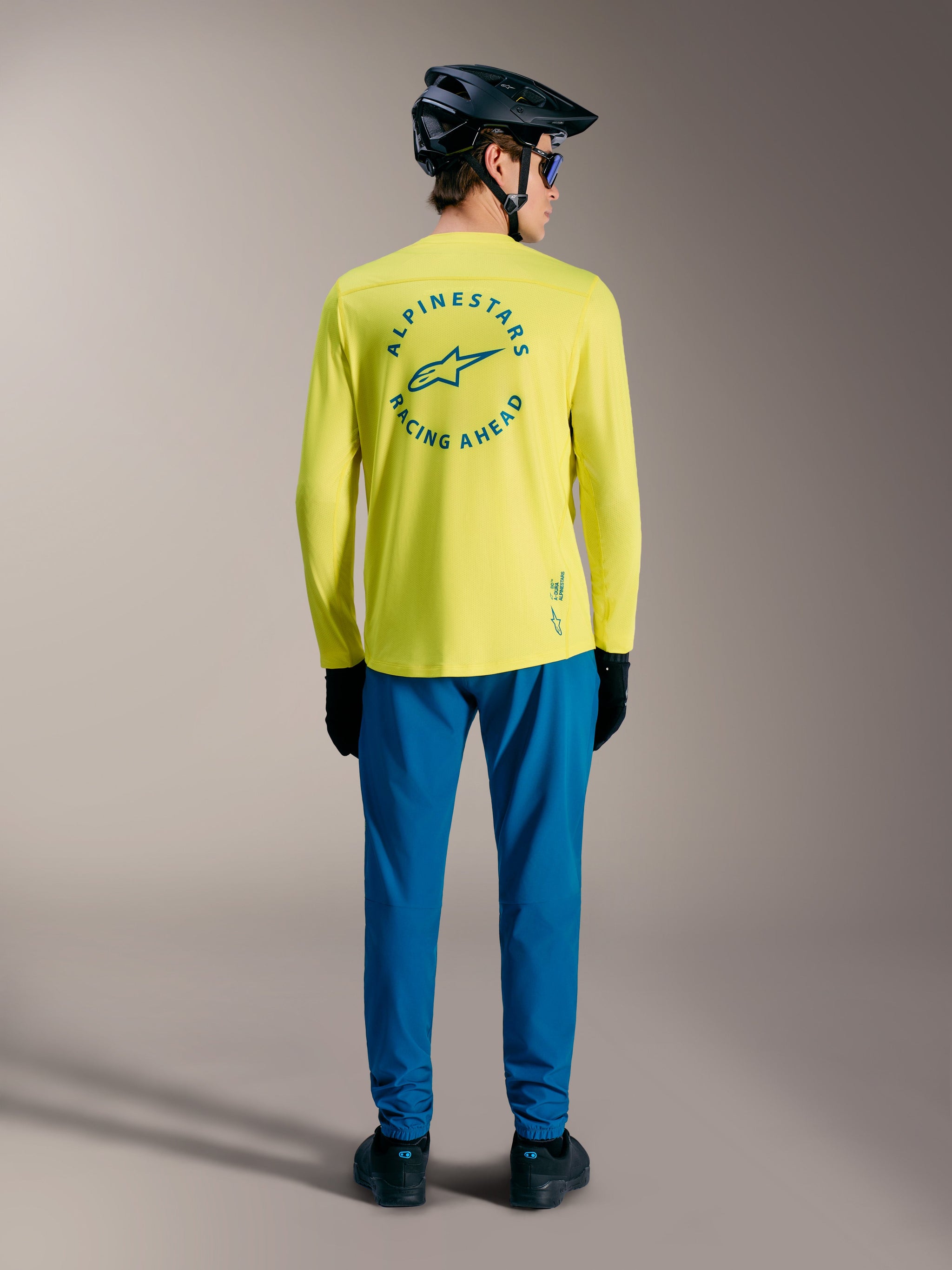 A-Dura Air Long Sleeve Jersey in Yellow Fluo featuring blue Racing Ahead circular back graphic and mountain bike gear.