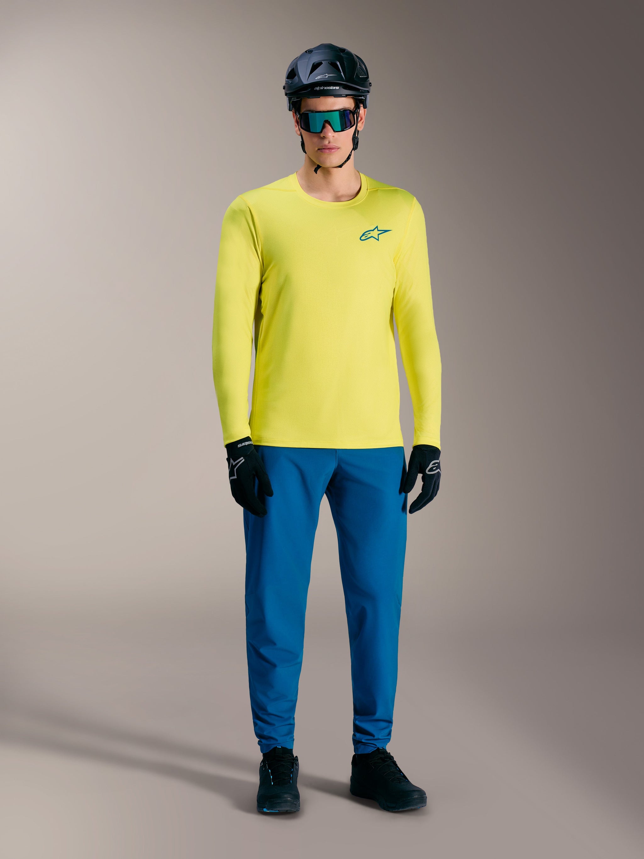 Yellow Fluo A-Dura Air Long Sleeve Jersey, breathable MTB top with Astars logo, styled with blue cycling pants and helmet.