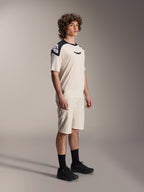 Alpinestars A-Aria Polartec Elite Short Sleeve Jersey, Ecru with black shoulder panels and logo, worn by a model with matching shorts and black shoes, performance mountain bike apparel for off-road trail riding.