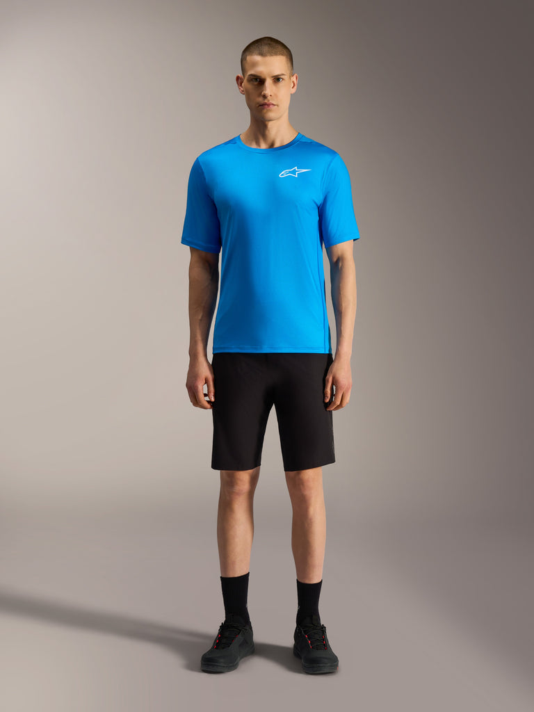 Alpinestars A-Dura Ride Shorts in black and bright blue jersey, performance mountain bike apparel for cycling on a model.