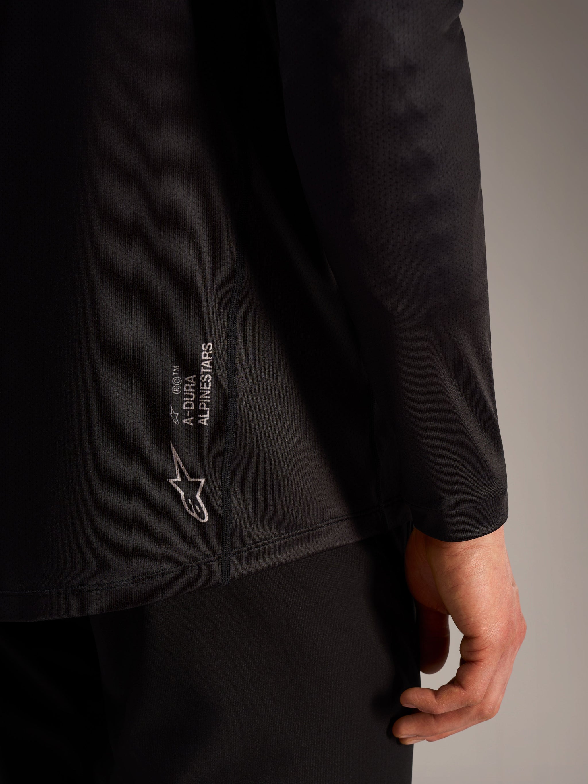 Black A-Dura Ride Long Sleeve Jersey with Alpinestars branding, featuring textured jacquard fabric for mountain biking.