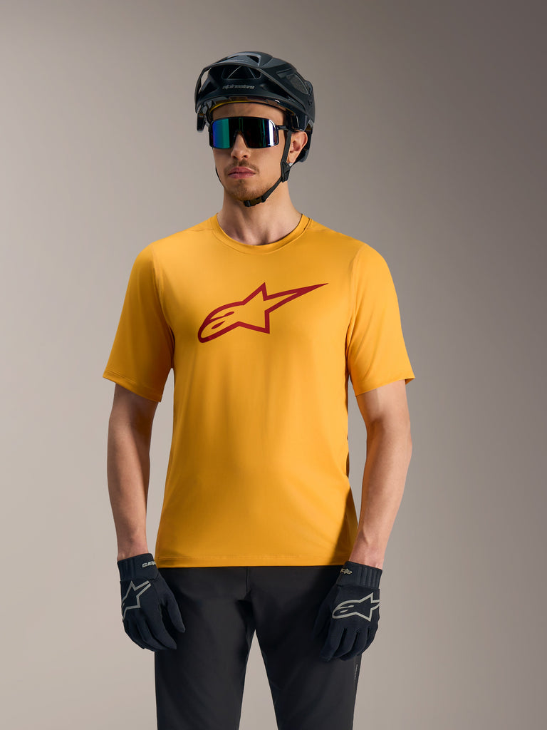 Orange A-Dura Ride Short Sleeve Jersey featuring a red Astars logo, styled with a mountain bike helmet and gloves.
