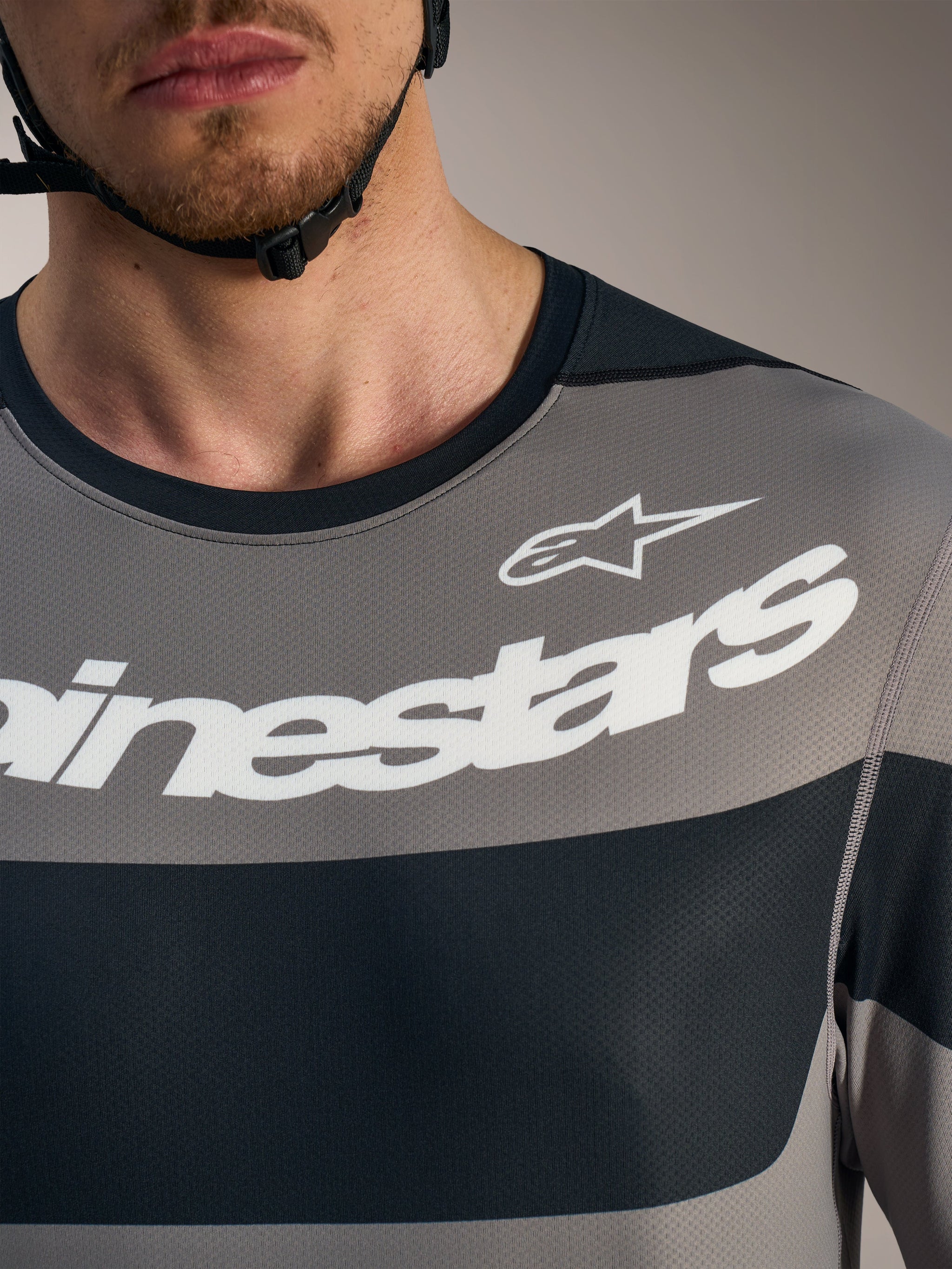 Gray A-Dura Race Long Sleeve Jersey chest detail with white Alpinestars logos and breathable technical mesh fabric.