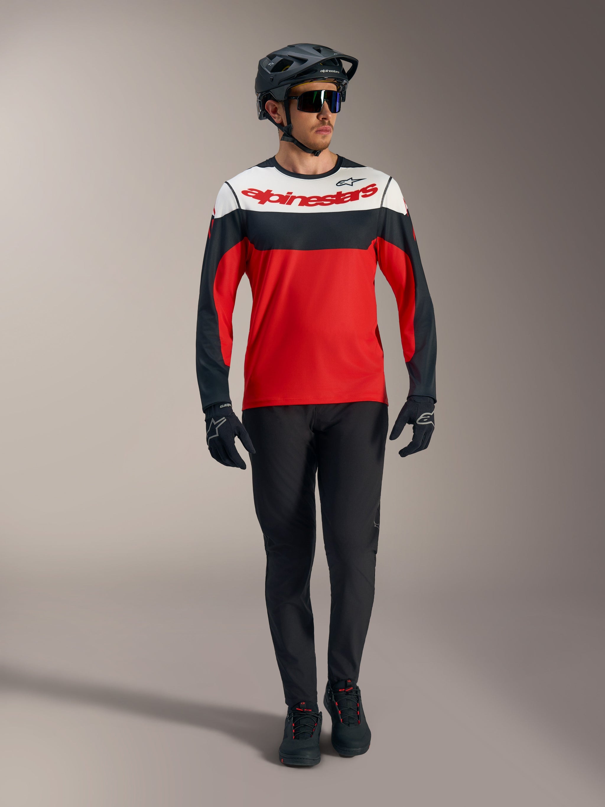 Red A-Dura Race Long Sleeve Jersey featuring white and black panels, paired with MTB pants and protective racing gear.