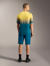 A-Dura ASTARS Jersey 2.0, short sleeve MTB top in yellow and blue-green gradient, shown from the back on a model.
