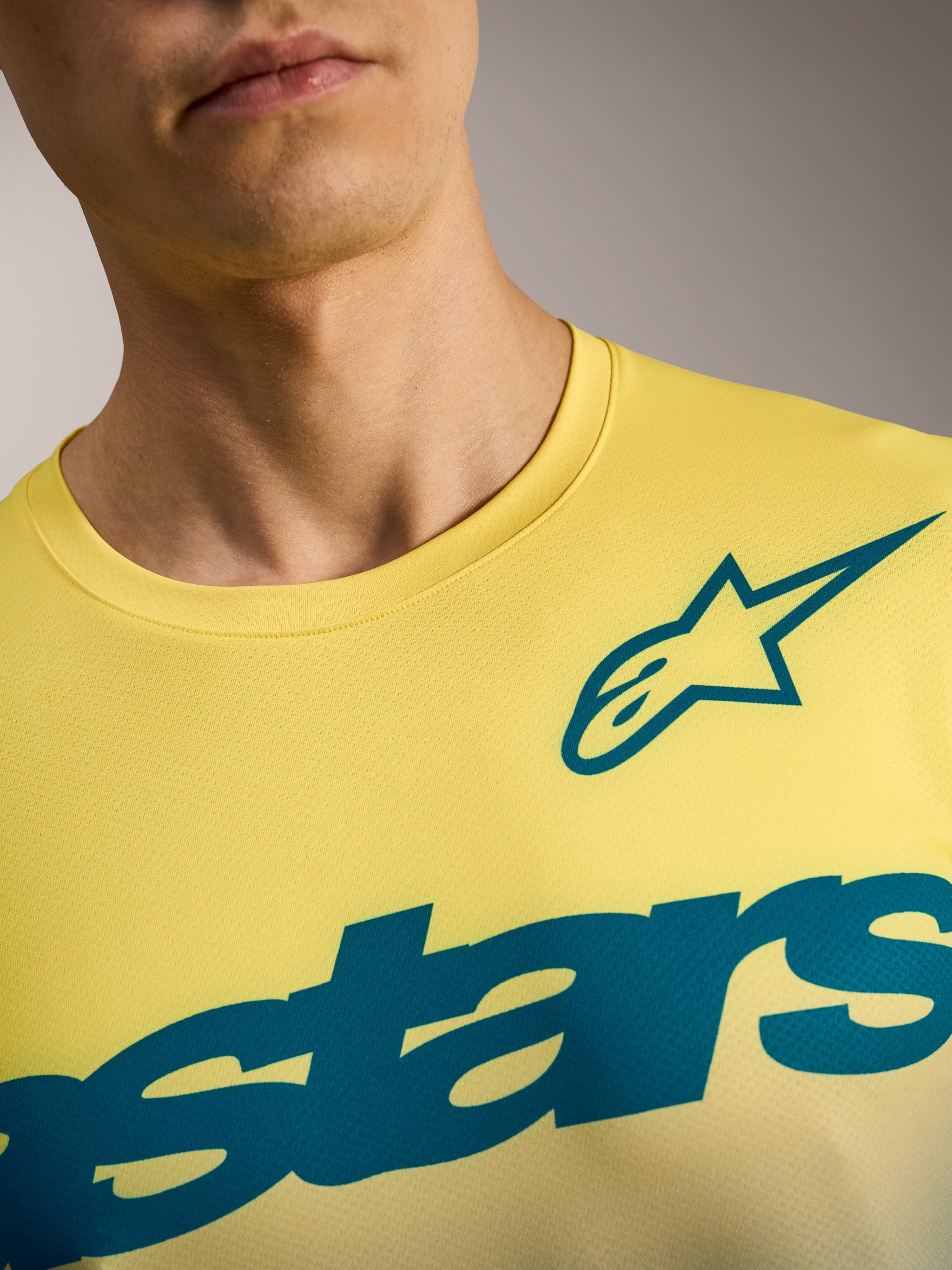 A-Dura ASTARS Jersey 2.0 in Yellow Fluo, featuring teal Alpinestars graphics on a breathable short sleeve MTB jersey.