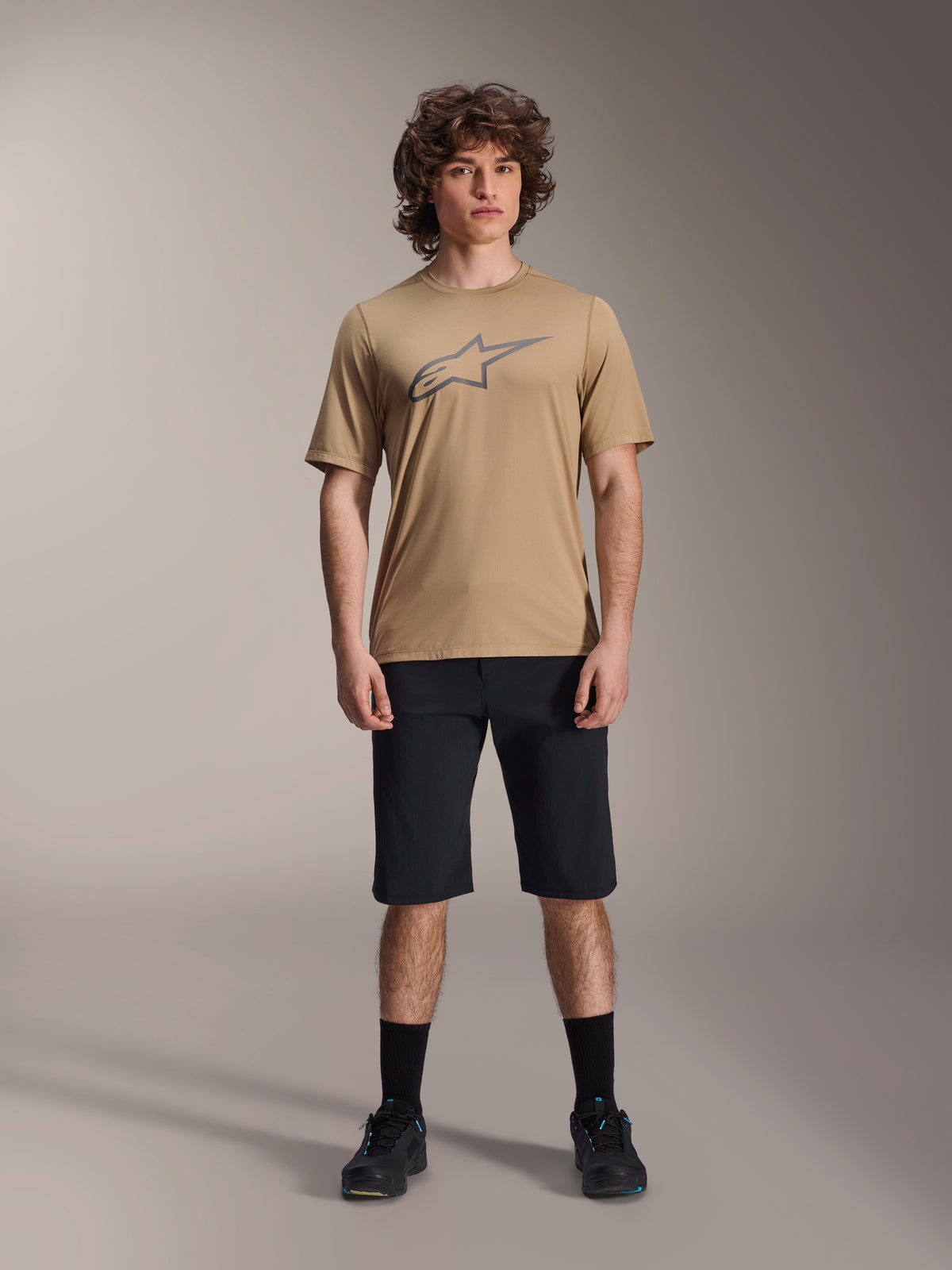 Alpinestars A-Dura Liner Shorts, MTB Shorts, Black, worn with tan short-sleeve jersey featuring a grey star logo, black socks and mountain bike shoes, casual athletic styling