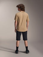 Male model from the back wearing Alpinestars A-Dura Shorts in Black and a tan A-Dura Short Sleeve Jersey, paired with black socks and mountain bike shoes, functional MTB trail outfit