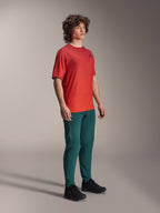 Alpinestars A-Dura Rise Jersey, Short Sleeve, Spicy Orange, featuring a small black chest logo, worn with dark teal pants and black shoes, lightweight moisture-wicking mountain bike apparel