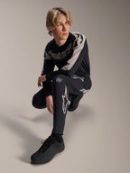Alpinestars A-Supra Melt Pants and Long Sleeve Jersey, Black and Grey, featuring bold white branding and star logos, worn by a male model in a crouching pose, coordinated MTB racing gear