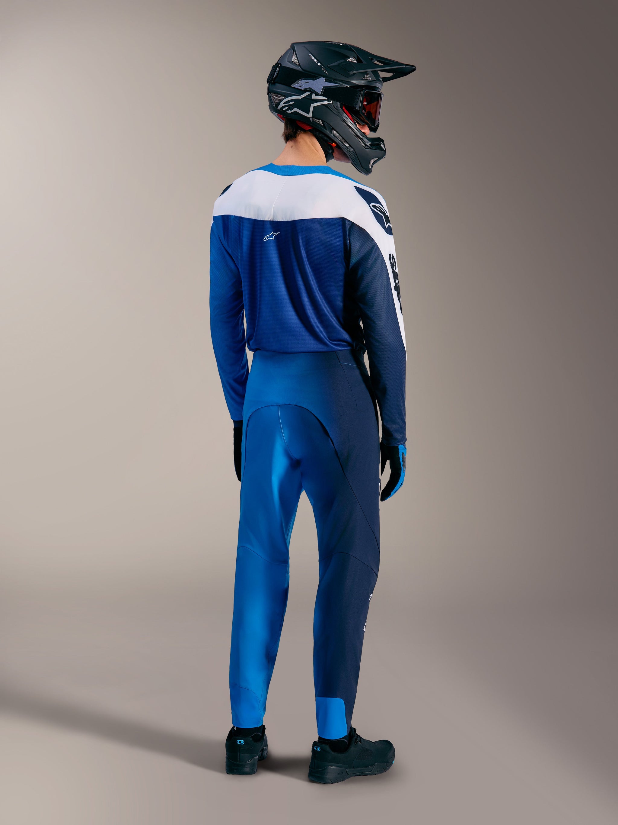 A-Supra Elite MTB gear in Faded Bright Blue, featuring matching jersey and pants from behind with a full-face helmet.