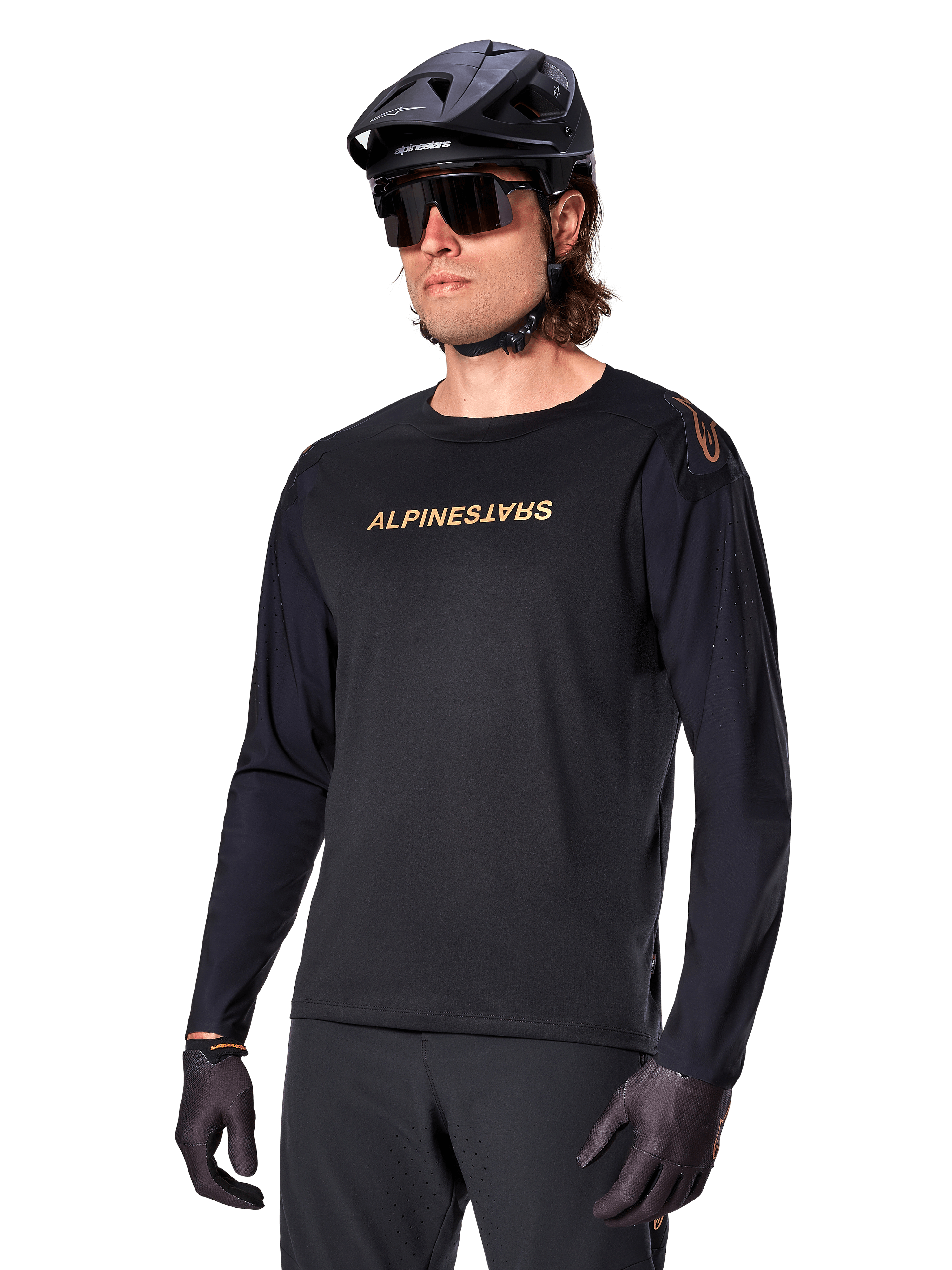 Alpinestars A-Aria Polartec Switch Long Sleeve Jersey, Black with gold logo, MTB mountain biking apparel, worn with a black helmet and sunglasses, featuring laser-cut ventilation on the sleeves and moisture-wicking Polartec fabric for off-road performance
