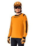 Alpinestars A-Dura Dri Wool Jersey - Long Sleeve, MTB Mountain Biking Jersey, Dark Gold and Black, featuring moisture-wicking merino wool blend and mesh panels, rider wearing matching helmet, sunglasses, and gloves