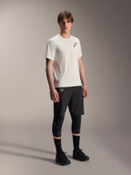 Alpinestars A-Aria Astar Jersey, Short Sleeve, Ecru, featuring black chest logo, worn with black cycling shorts and knee protectors, lightweight MTB performance gear