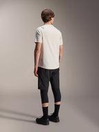 Alpinestars A-Aria Astar Jersey, Short Sleeve MTB Jersey, Ecru, back view showing the performance fit and longer drop tail, styled with black mountain bike shorts, knee protectors, and black riding shoes for off-road trail sessions