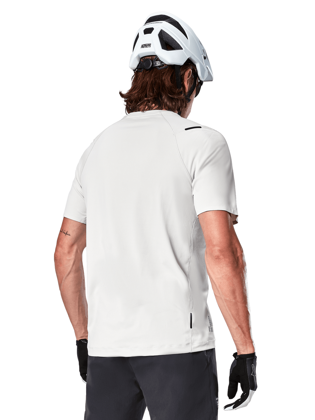 Alpinestars A-Aria Astar Jersey, Short Sleeve, White Dove, rear view of lightweight breathable mountain bike jersey, worn with a white helmet and black cycling gloves, featuring a dropped tail for extra coverage