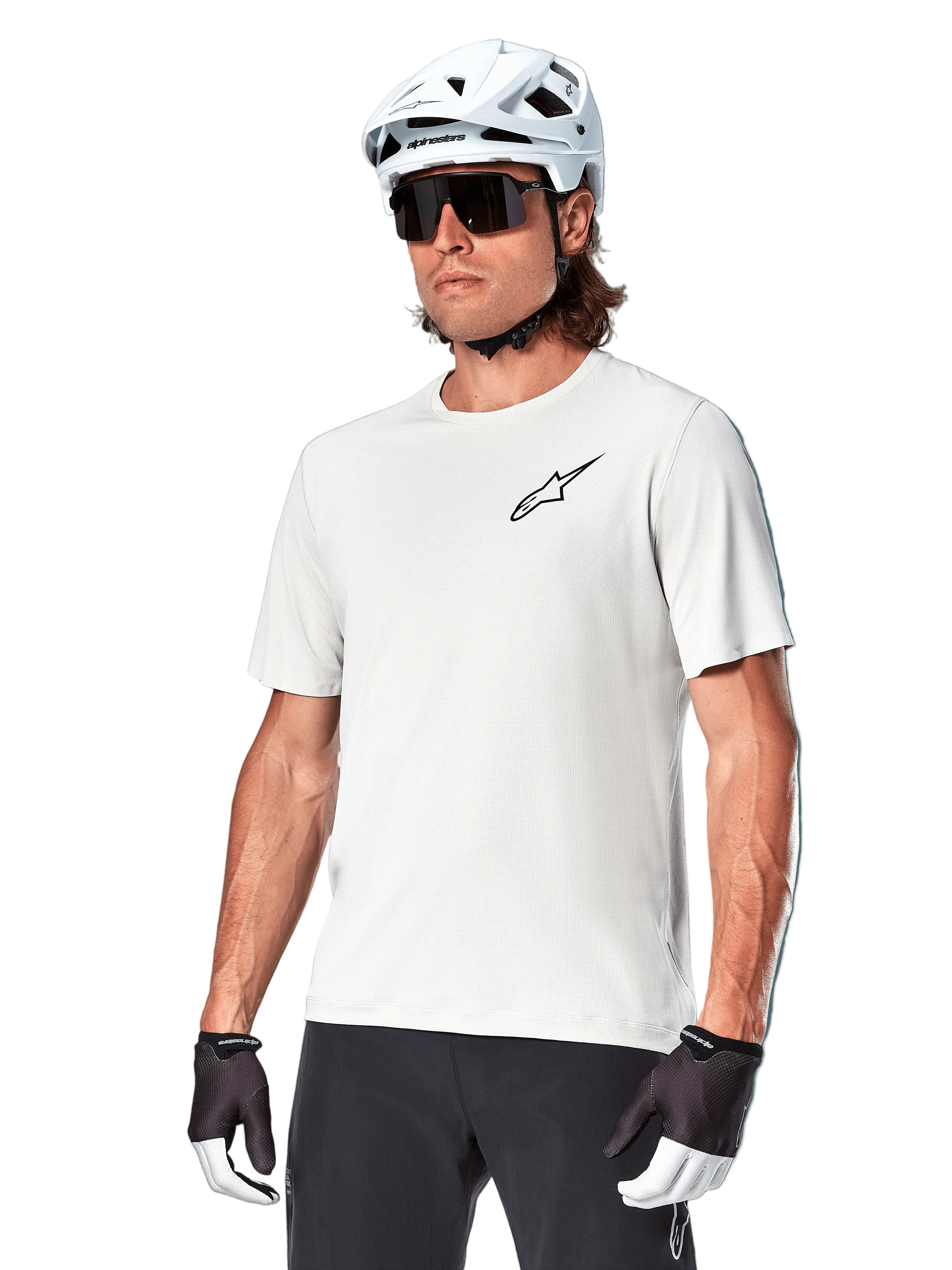 Alpinestars A-Aria Astar Short Sleeve Jersey, White Dove, worn by a cyclist with a white helmet and dark sunglasses, featuring a small black star logo on the chest, breathable performance gear for mountain biking