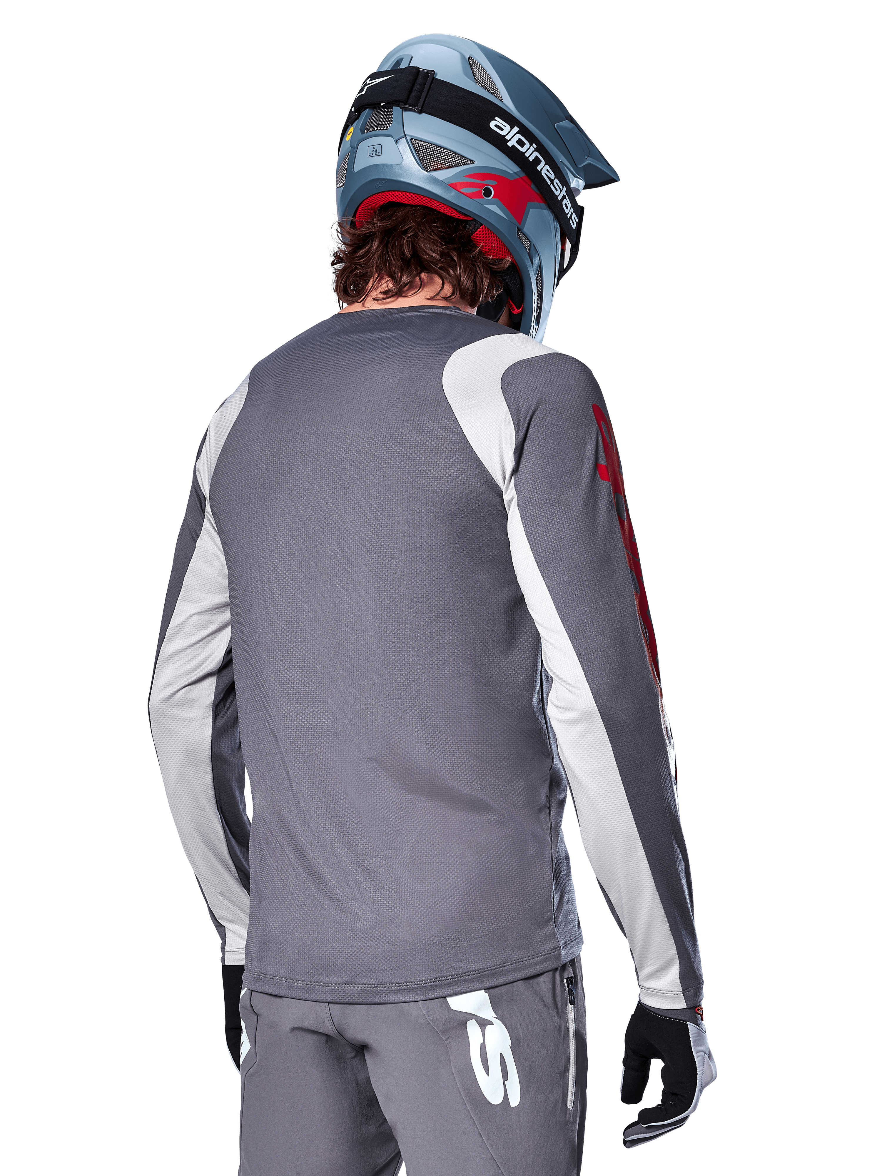 Alpinestars A-Supra Astar Long Sleeve Jersey, Dark Gray with light gray shoulder and arm panels, rear view of rider wearing a blue full-face mountain bike helmet and gray pants, performance-fit MTB cycling apparel