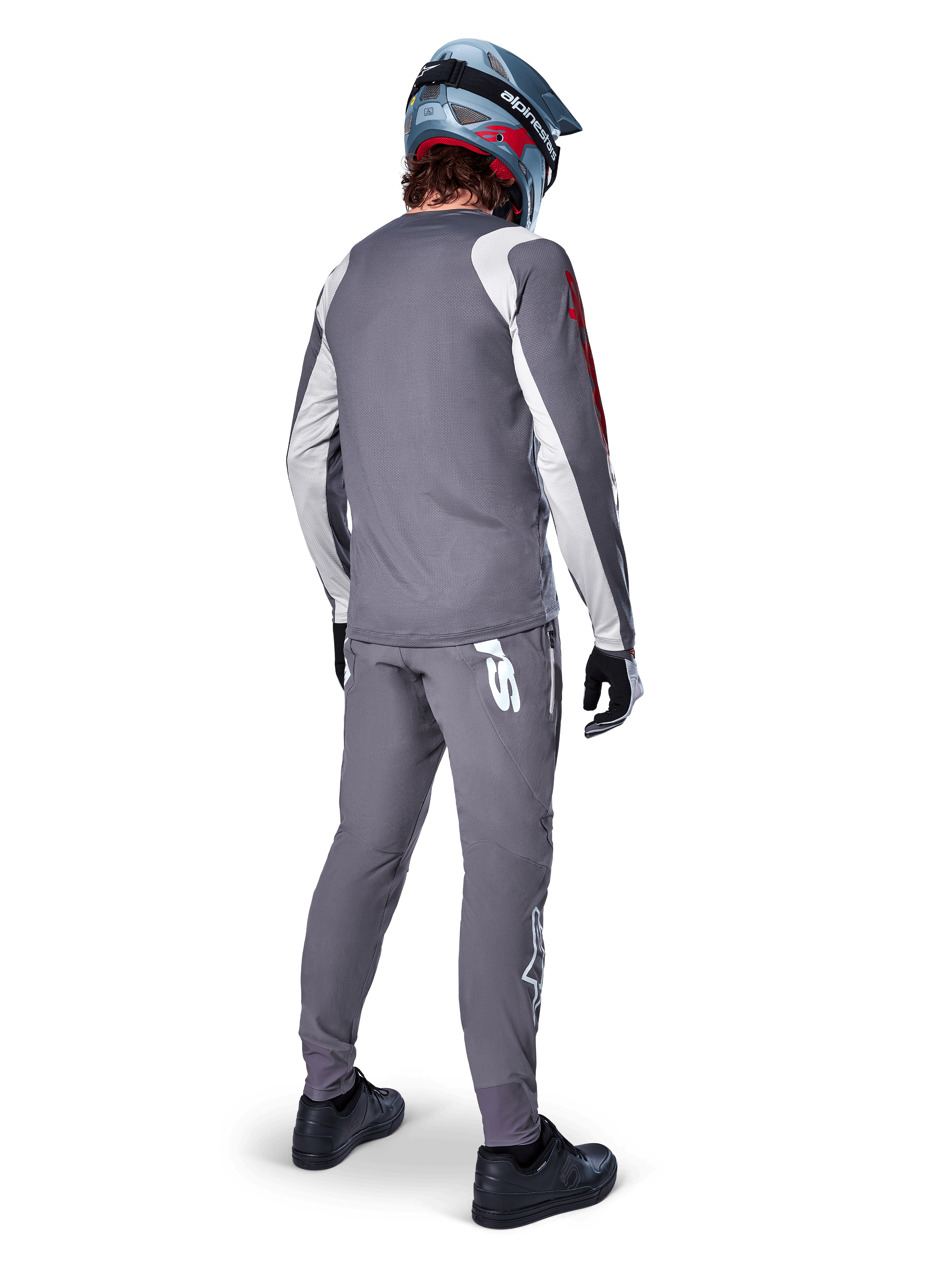 Alpinestars A-Supra Astar Jersey, Long Sleeve MTB Jersey, Dark Gray with white sleeve accents and red logo, back view of rider wearing matching gray pants and blue full-face helmet, performance cycling apparel