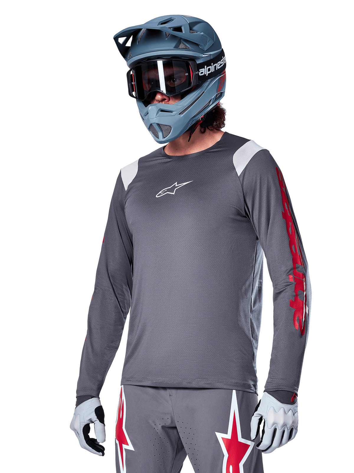 Alpinestars A-Supra Astar Long Sleeve Jersey, MTB Mountain Biking Jersey, Dark Gray with Red and White accents, performance fit, worn with matching gray pants featuring red and white star graphics, complete off-road cycling outfit with full-face helmet and gloves