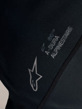 Close-up detail of black Stella A-Dura Ride Jersey with white Alpinestars logo and A-DURA branding on jacquard fabric.