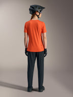 Alpinestars Women's Stella A-Dura Ride Short Sleeve Jersey in orange, back view with black MTB pants and helmet.