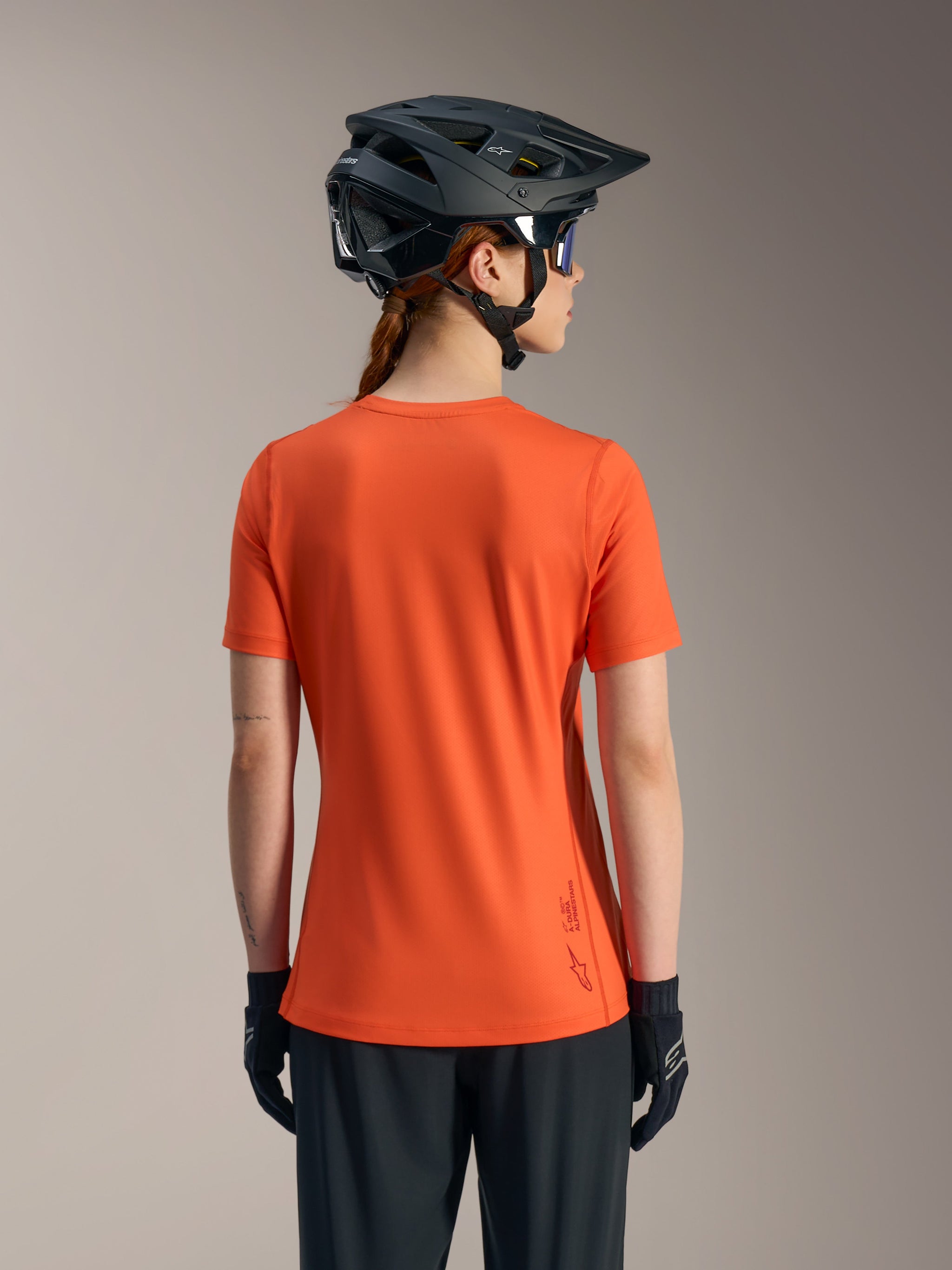 Orange Stella A-Dura Ride Jersey, back view of short sleeve women's MTB top made with recycled performance fabric.