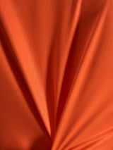 Orange jacquard fabric detail of the Alpinestars Stella A-Dura Ride Jersey, showing its lightweight and stretchy texture.