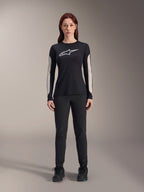 Woman wearing Alpinestars Stella A-Dura Dri Astar Long Sleeve Jersey, Black with white chest logo and light-colored mesh sleeve panels, paired with black pants and black shoes, technical mountain bike apparel