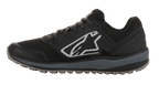 Alpinestars Meta Trail Shoes, performance running shoe, Black and Dark Gray, side profile featuring large white Astars logo, dark gray midsole, lugged oil-resistant rubber sole, designed for paddock comfort and motorsport crew use.