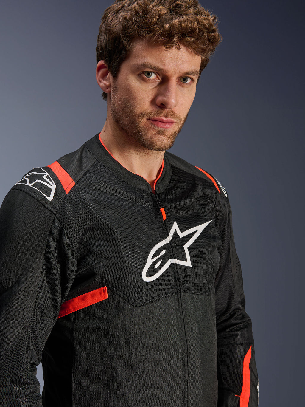 Alpinestars T-Sps Air V2 Jacket, Black with Red Fluo accents, Textile Mesh Motorcycle Jacket, worn by model, featuring white Alpinestars logo on chest and shoulders, breathable mesh panels, sporty urban riding style