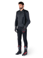 Alpinestars Missile V3 Leather Jacket, Black, worn by a rider with black pants and black and red racing gloves and boots, featuring perforated leather panels and sleek monochromatic branding, professional racing sport aesthetic